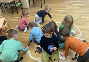 przedszkolaki układaja kształt dyni z kasztanów