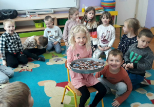 dziewczynka trzyma na tacy czekoladowe pierniczki