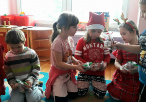 dzieci oglądają prezenty otrzymane od Mikołaja