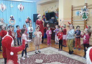 dzieci ubrane w czerwone stroje tańczą