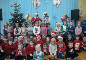 dzieci na tle świątecznej dekoracji pozuja do zdjęcia