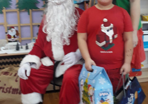 chłopiec pozuje do zdjęcia z Mikołajem i Elfem
