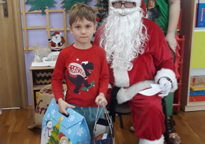 chłopiec pozuje do zdjęcia z Mikołajem i Elfem