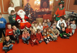 dzieci pozują do zdjęcia z Mikołajem i Elfem
