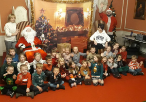 dzieci pozują do zdjęcia z Mikołajem