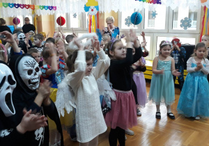 dzieci w strojach karnawałowych tańcza do wesołej muzyki